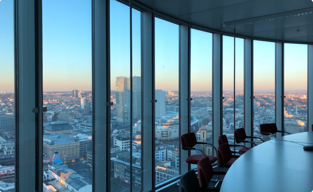 A ClimateTech office with a city at sunset though glass windows.