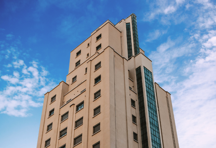 An example of the kind of hotels Parity can work with. This image is of a tan hotel with glass windows in front of a blue sky.