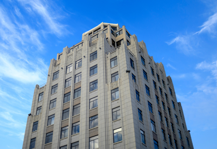 An example of a builidng classified as a Multifamily Condos & Co-Ops that Parity can work with. This building is a tall condo or co-op with a white brick facade and a blue sky background.