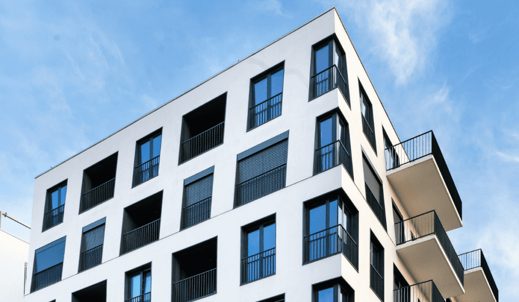 A white residential condo building with balconies. Parity can Optimize the HVAC systems in this kind of building.